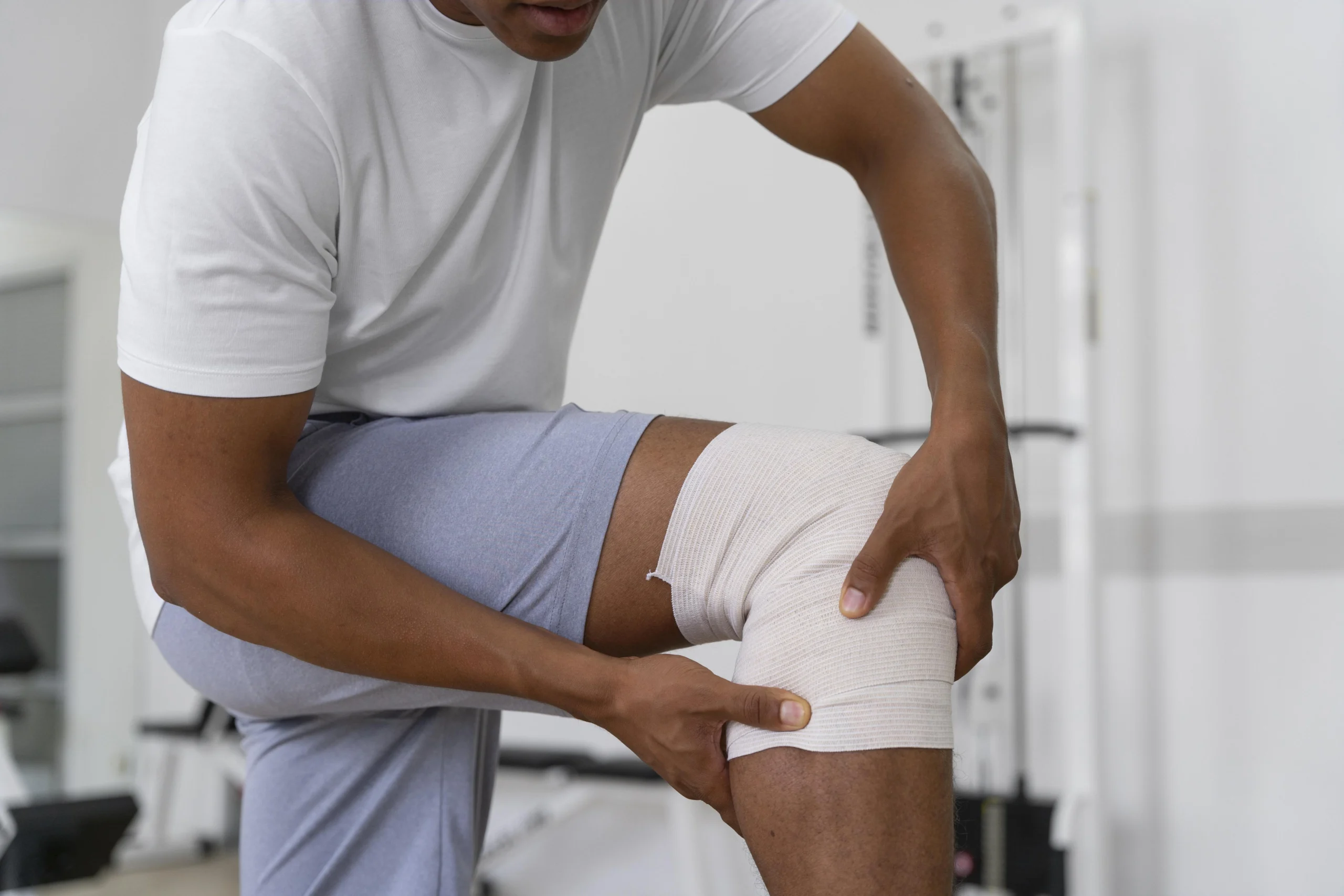 Patient applying knee support bandage – orthopedic and sports injury care at Ashtavinayak Multispeciality Hospital, Panvel